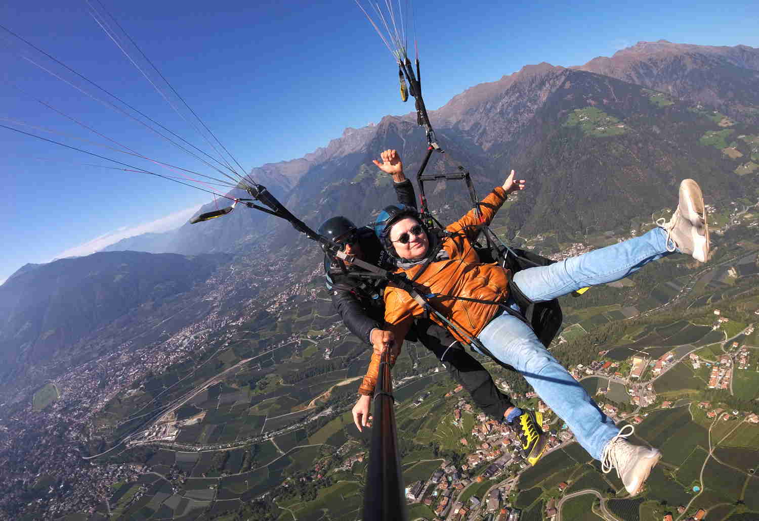 Tandemflug Südtirol, Trulla fliegt mit ausgestreckten Armen und Beinen über Meran