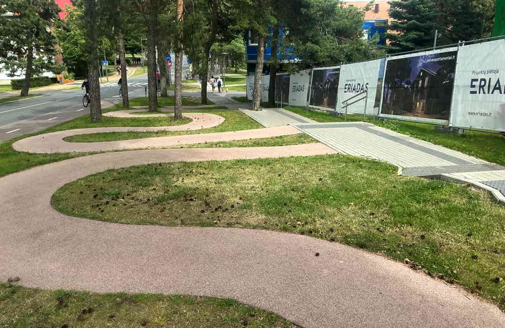 In Schlangenlinien gebaute Rollstuhlrampe zur Umgehung einer Treppen an einem Gehweg in Nida